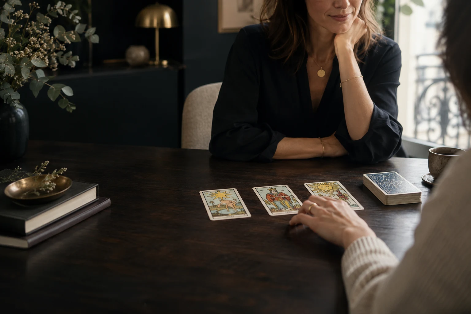 Une cliente choisit une carte pendant une consultation de tarot